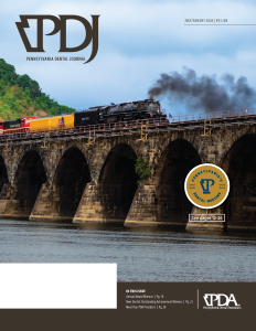 Train crossing a stone arch bridge on a blue-sky landscape, with a large 'Pennsylvania Dental Journal' logo in the top left and a circular 'See pages 12–26' badge on the right.